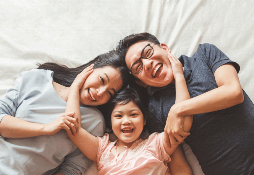 Picture of a happy family lying down on bed